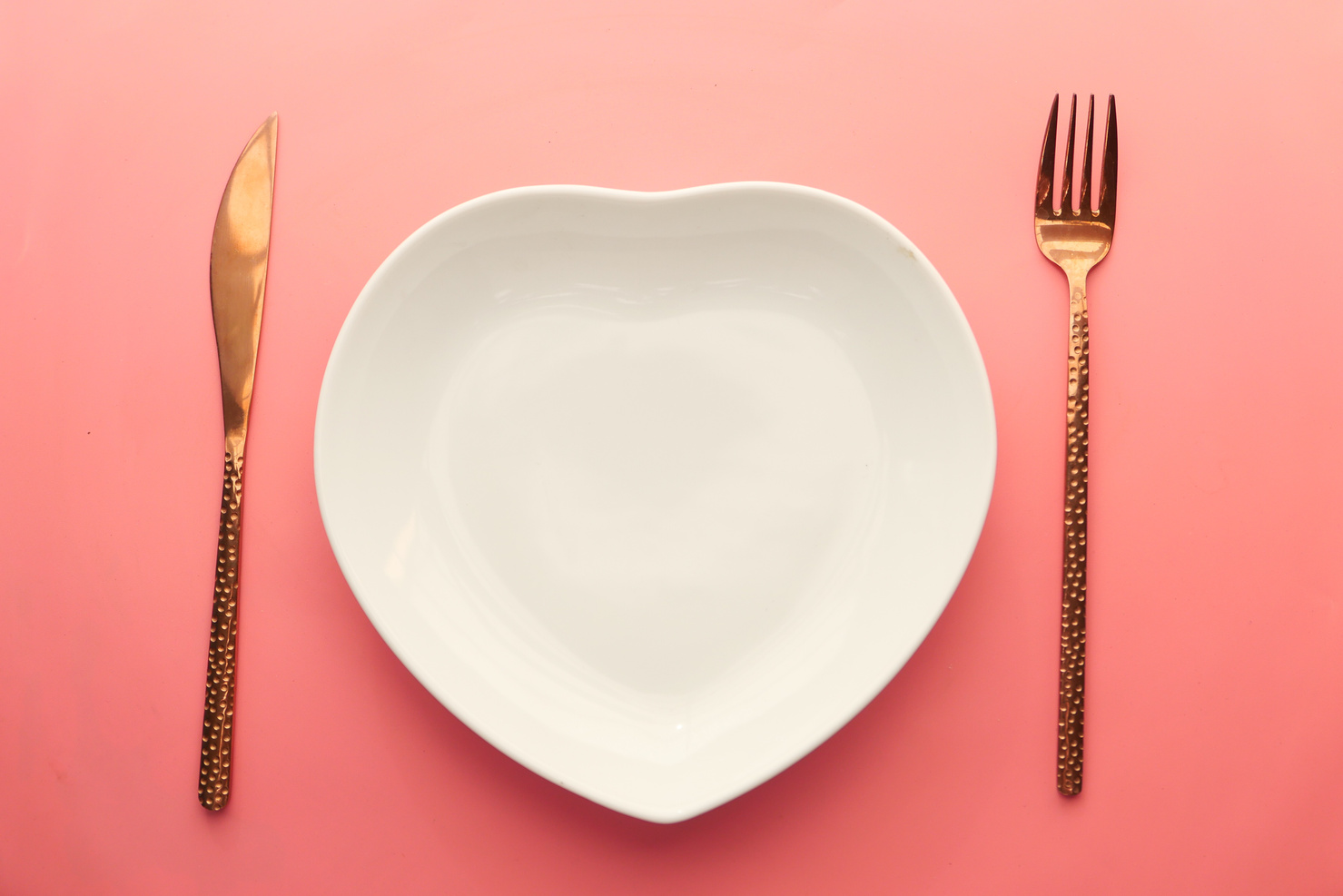 Cutlery and Empty Plate on Pink Background Top down
